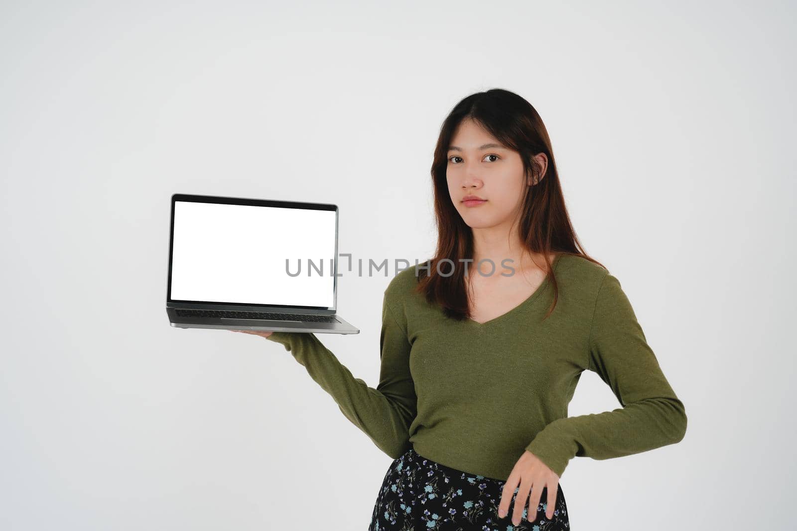 young asian girl holding a laptop and show blank white sreen, isolated on white background.