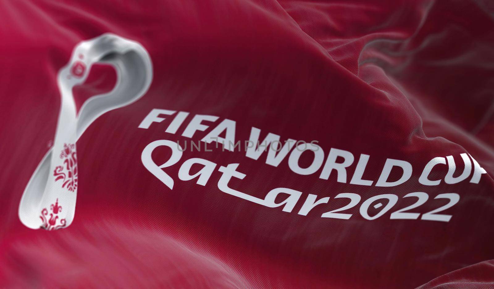 Doha, Qatar, April 2022: A flag with the Qatar 2022 Fifa World Cup logo flapping in the wind. The event is scheduled in Qatar from 21 November to 18 December 2022