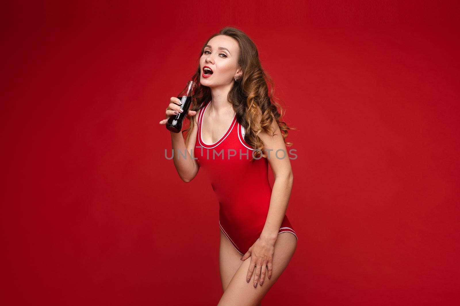 Beautiful female model posing on red background.