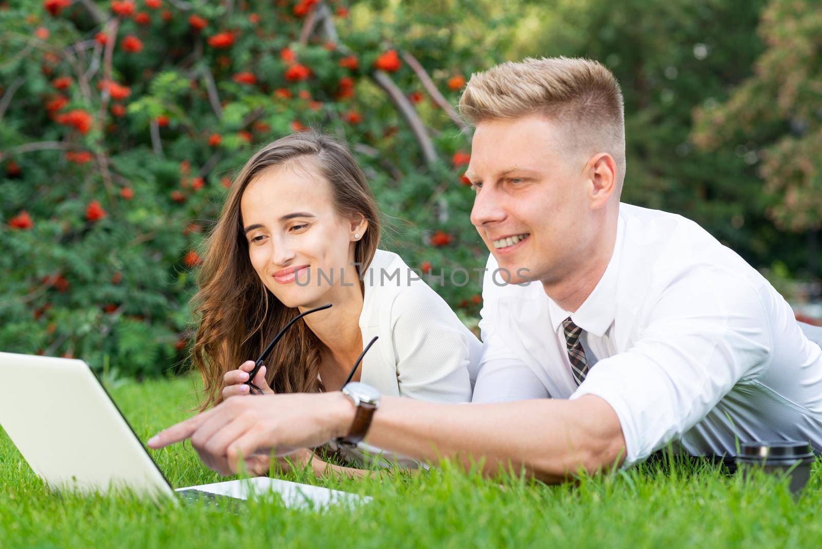 close-up portrait of businessmen in the park with a laptop. create a project together