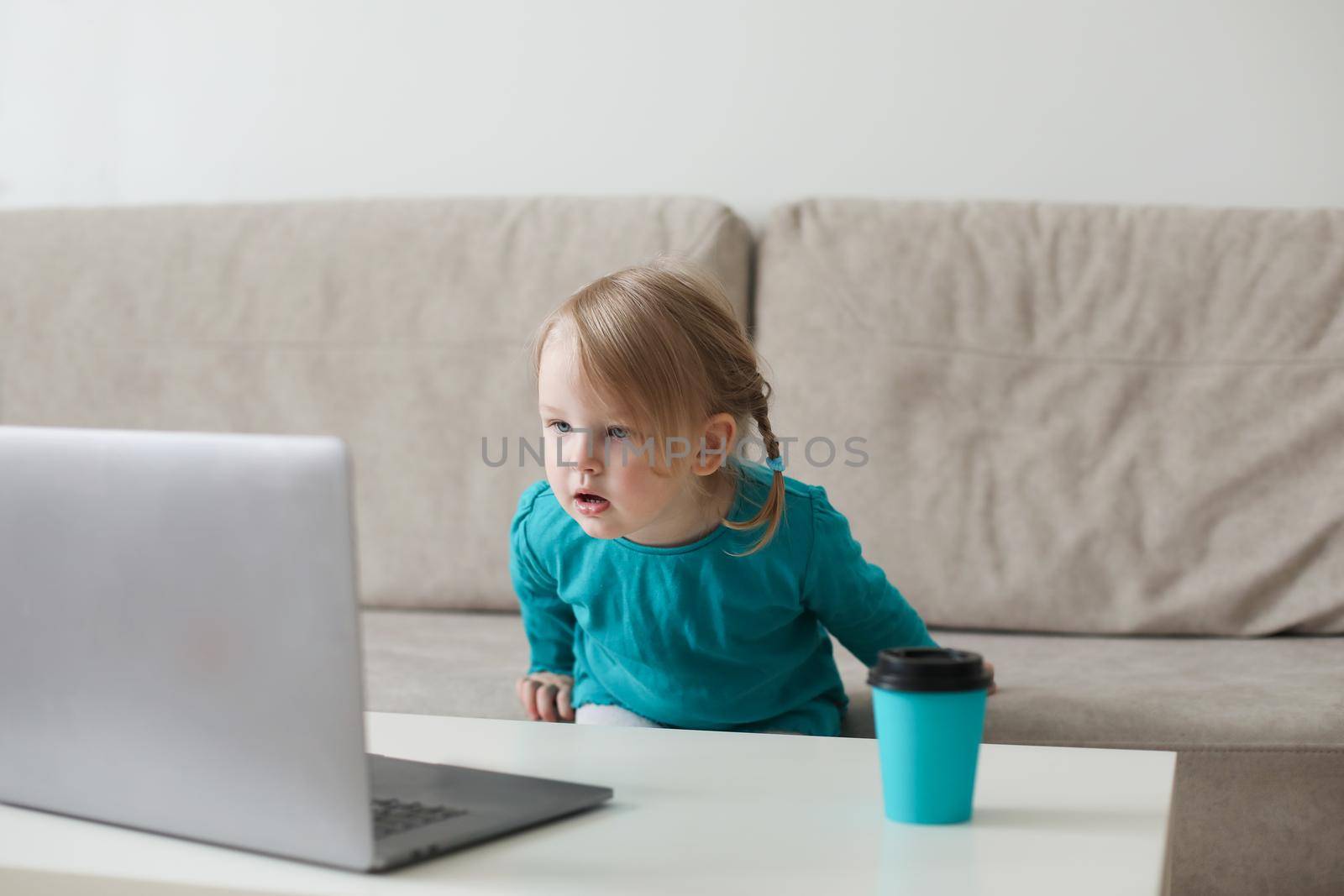 little girl uses a laptop video chat to communicate learning at home, child studying online