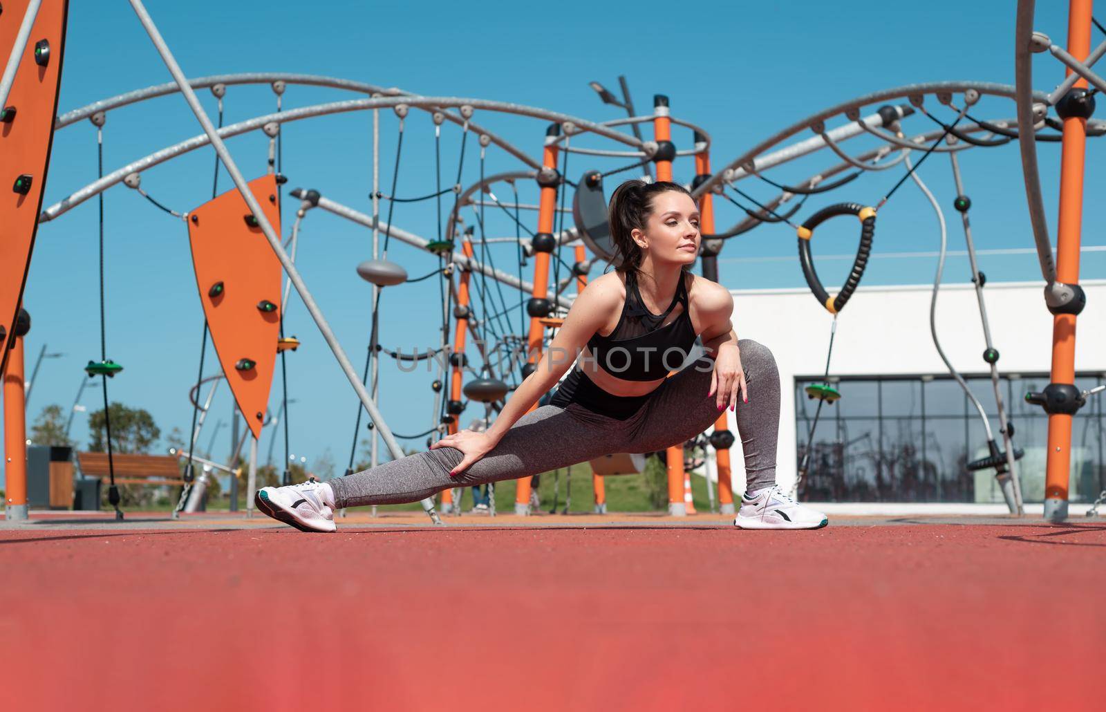 sporty girl does fitness on a sports field in the summer outdoors