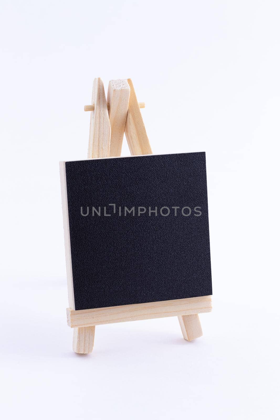 Wooden Easel Miniature with Blank Black Square Canvas for Artists and Painters - Mockup. Mini Wooden Stand with Clean Artboard on White Background, Copy Space