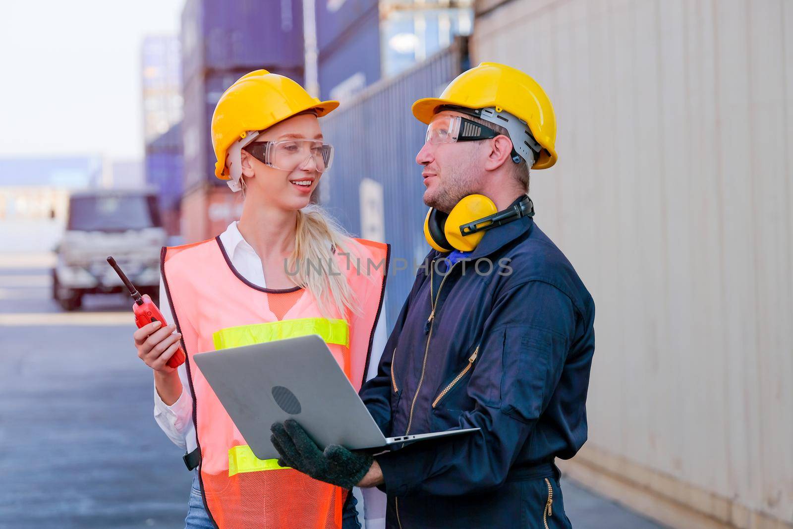 Worker man and woman discuss about their system and express happy emotion in cargo container shipping area.