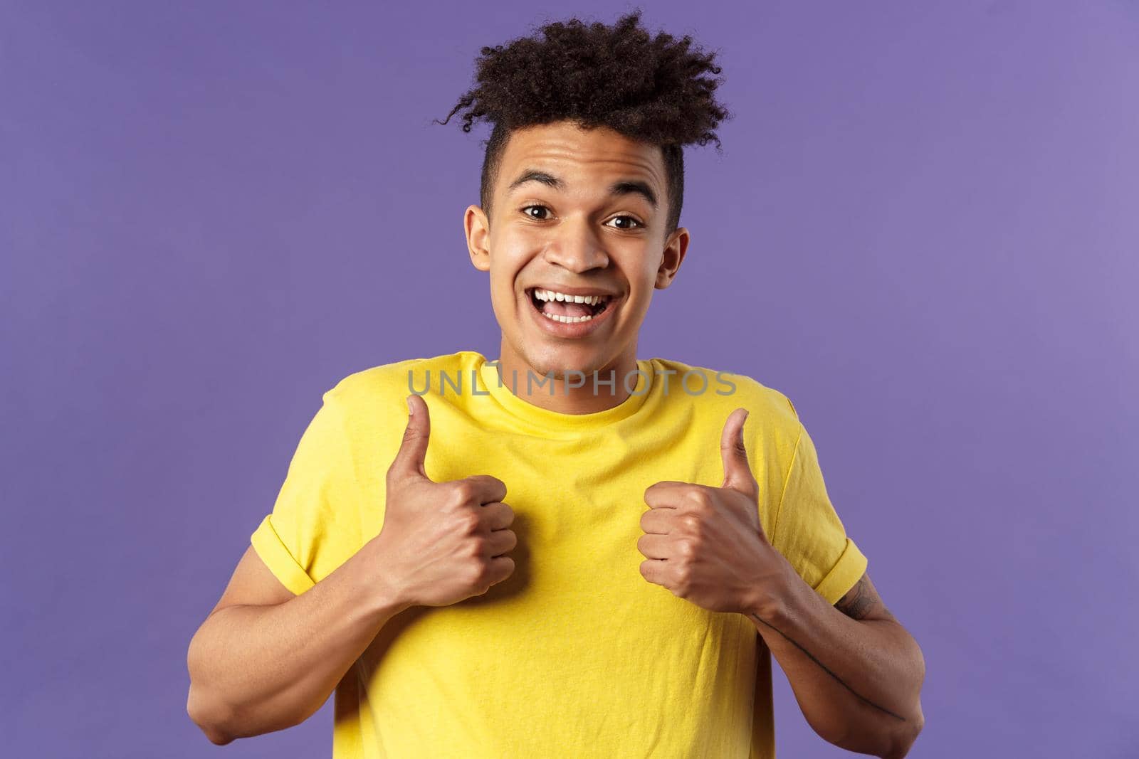 Close-up portrait of enthusiastic healthy hispanic guy staying positive, show thumbs-up and smiling, encourage people stay home, feel fine, like and approve friends plan, standing purple background.