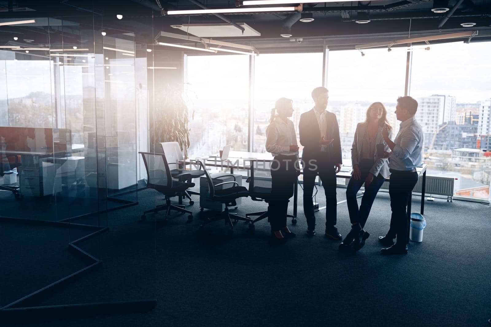 Business team standing against panoramic windows in modern office by Yaroslav_astakhov