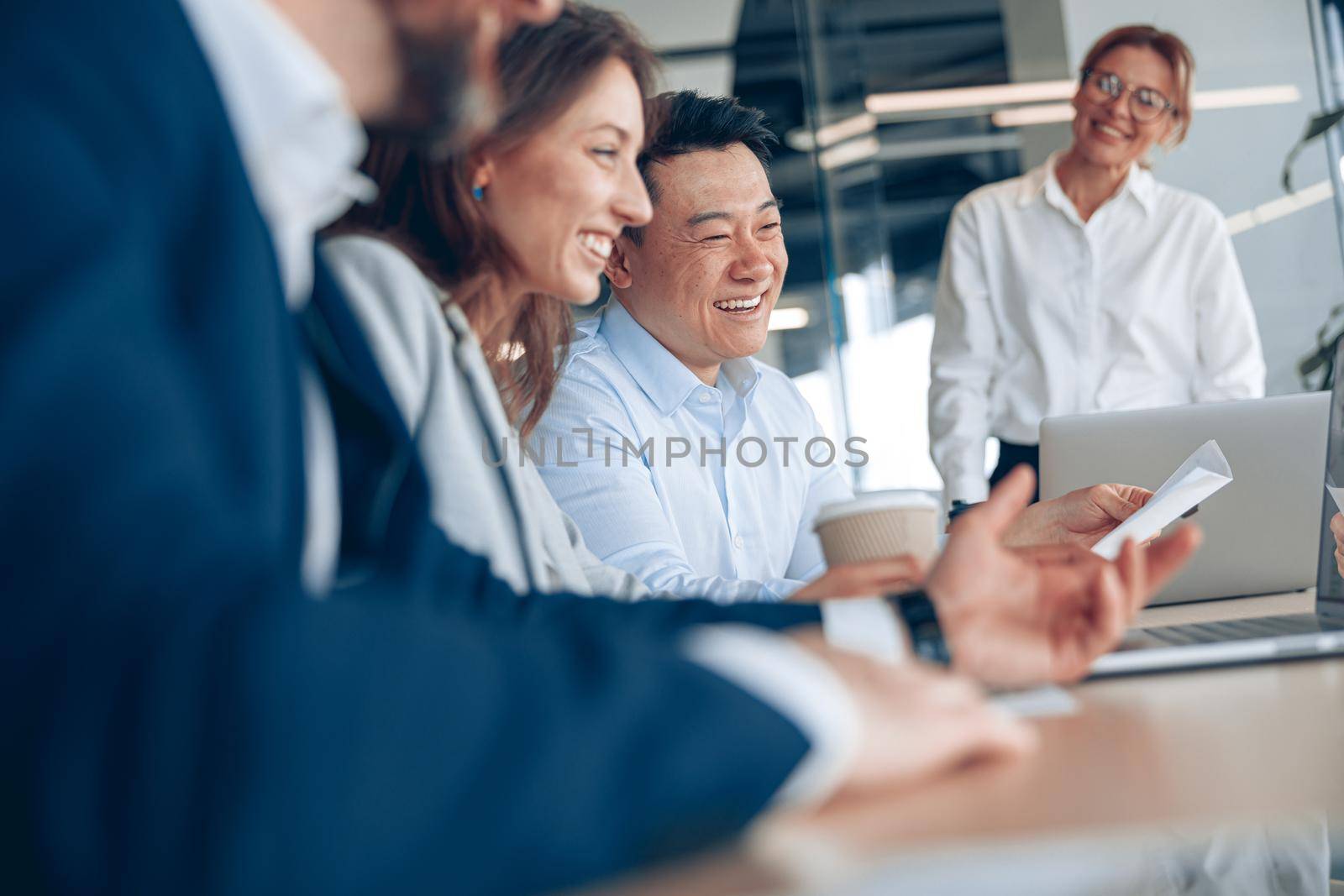 Close up of smiling confident businesswoman on business meeting with colleagues in office