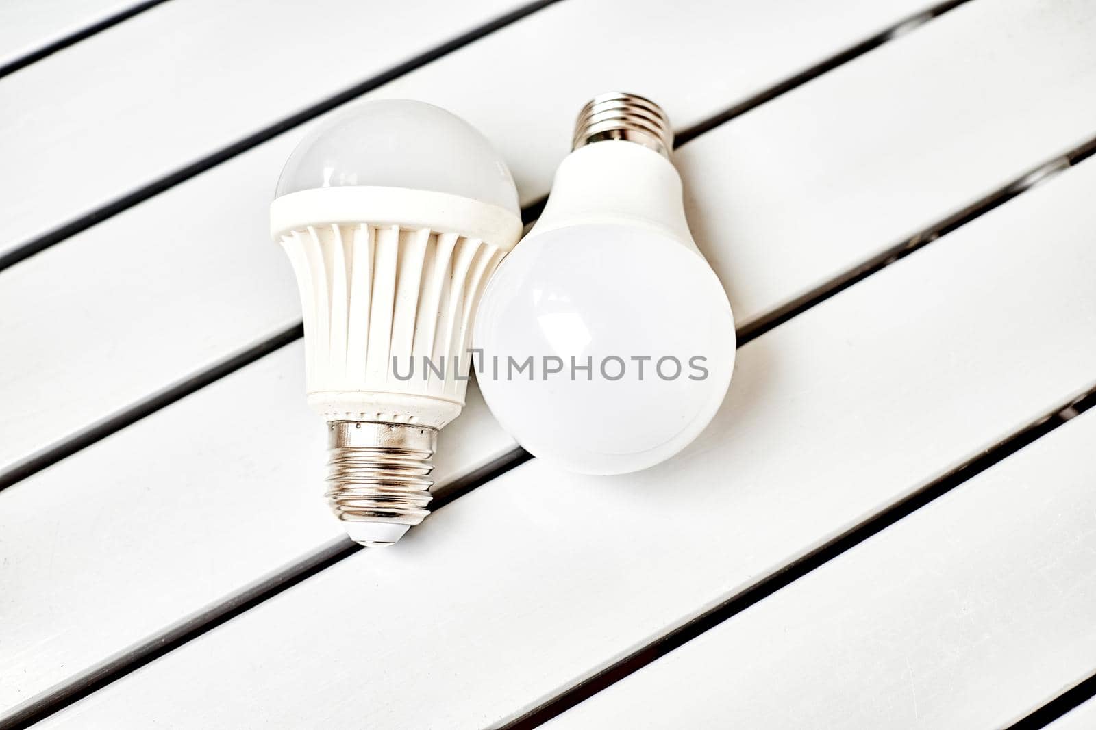 Two LED bulbs on a striped table by jovani68