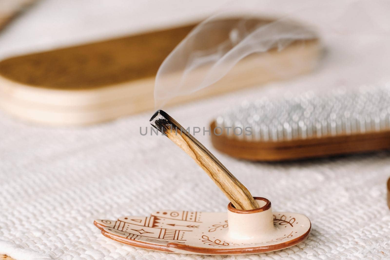 A smoking Palo Santo stick and boards with nails for yoga classes.