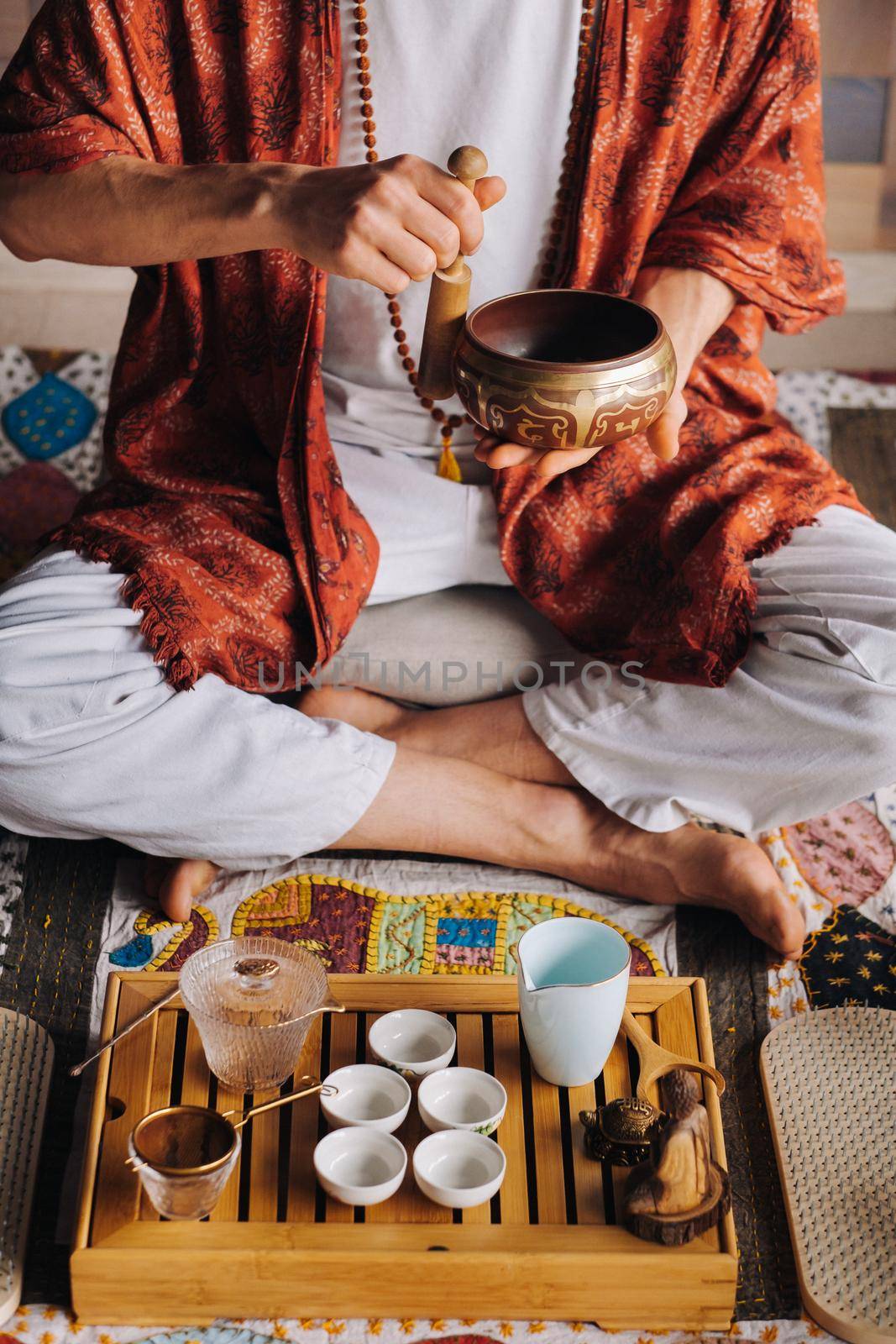 Tibetan singing bowl in the hands of a man during a tea ceremony.