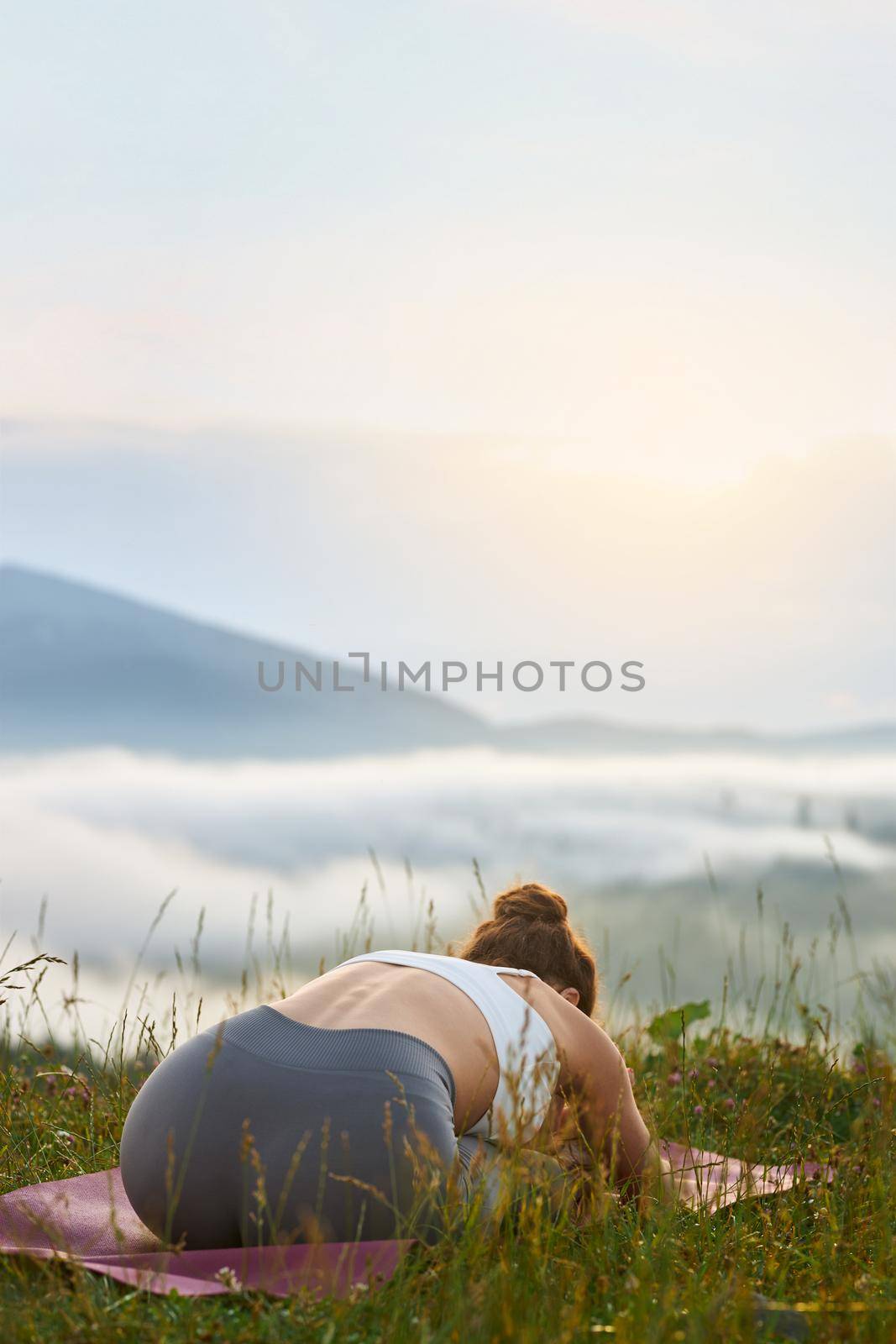 Girl practicing yoga in mountains. by SerhiiBobyk