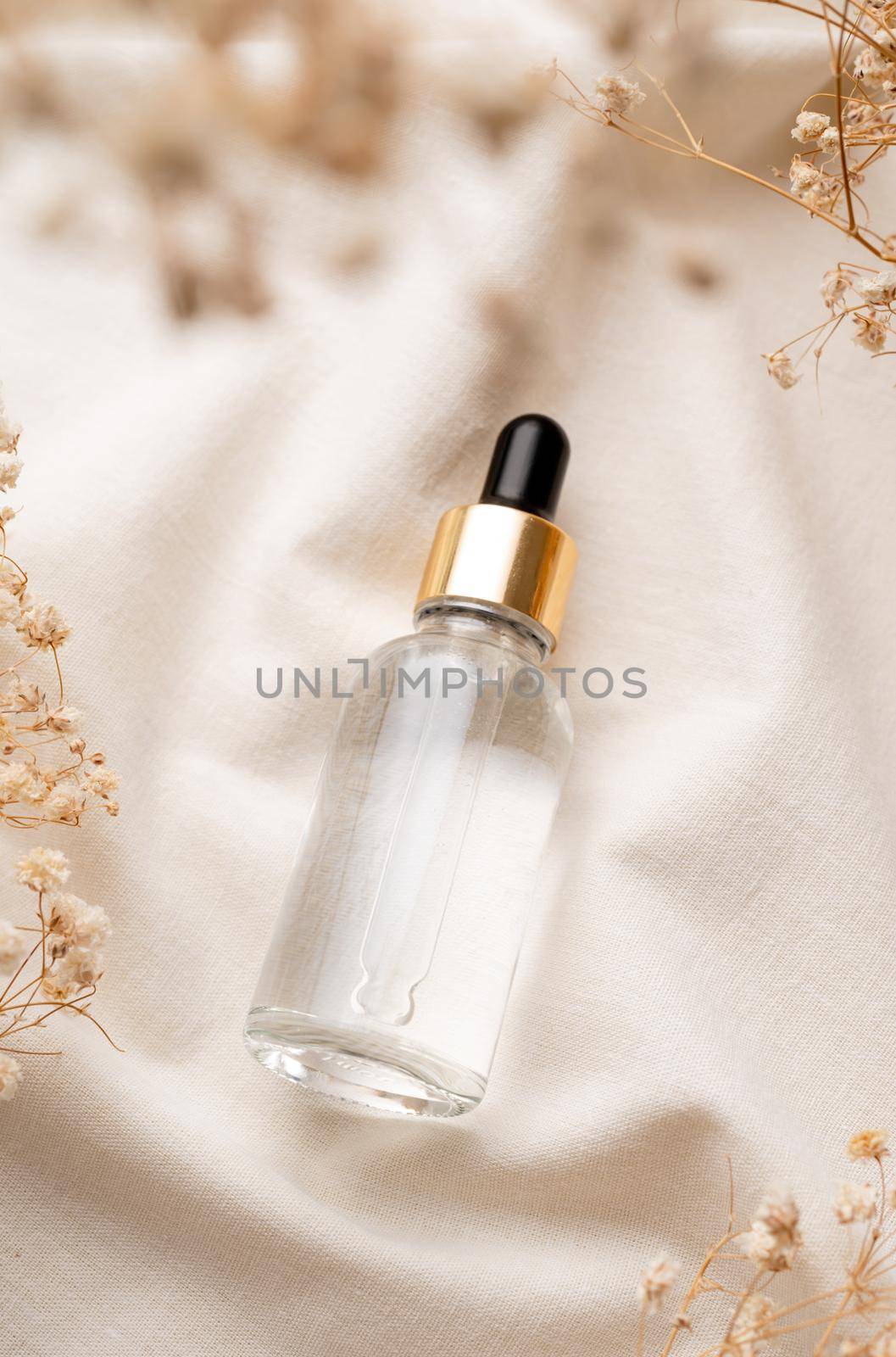 top view of glass essential oil droppper bottle with pipette on fabric wavy background, mockup design