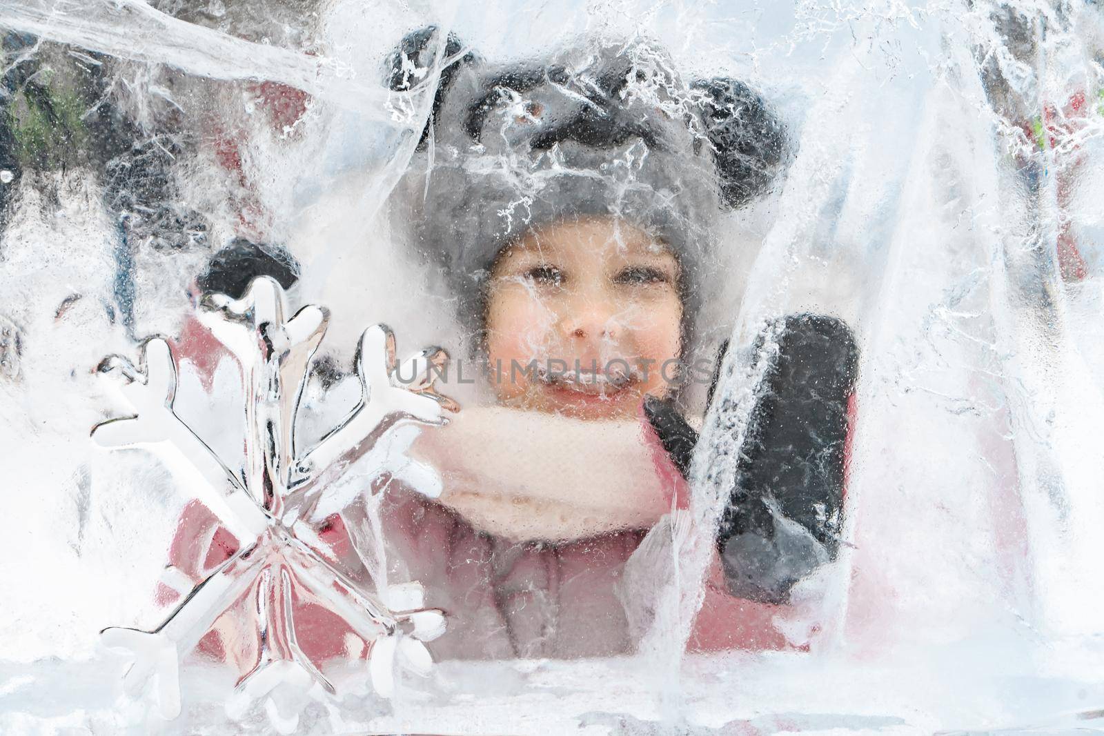 little girl in a knitted hat and scarf and ice sculptures by Lena_Ogurtsova