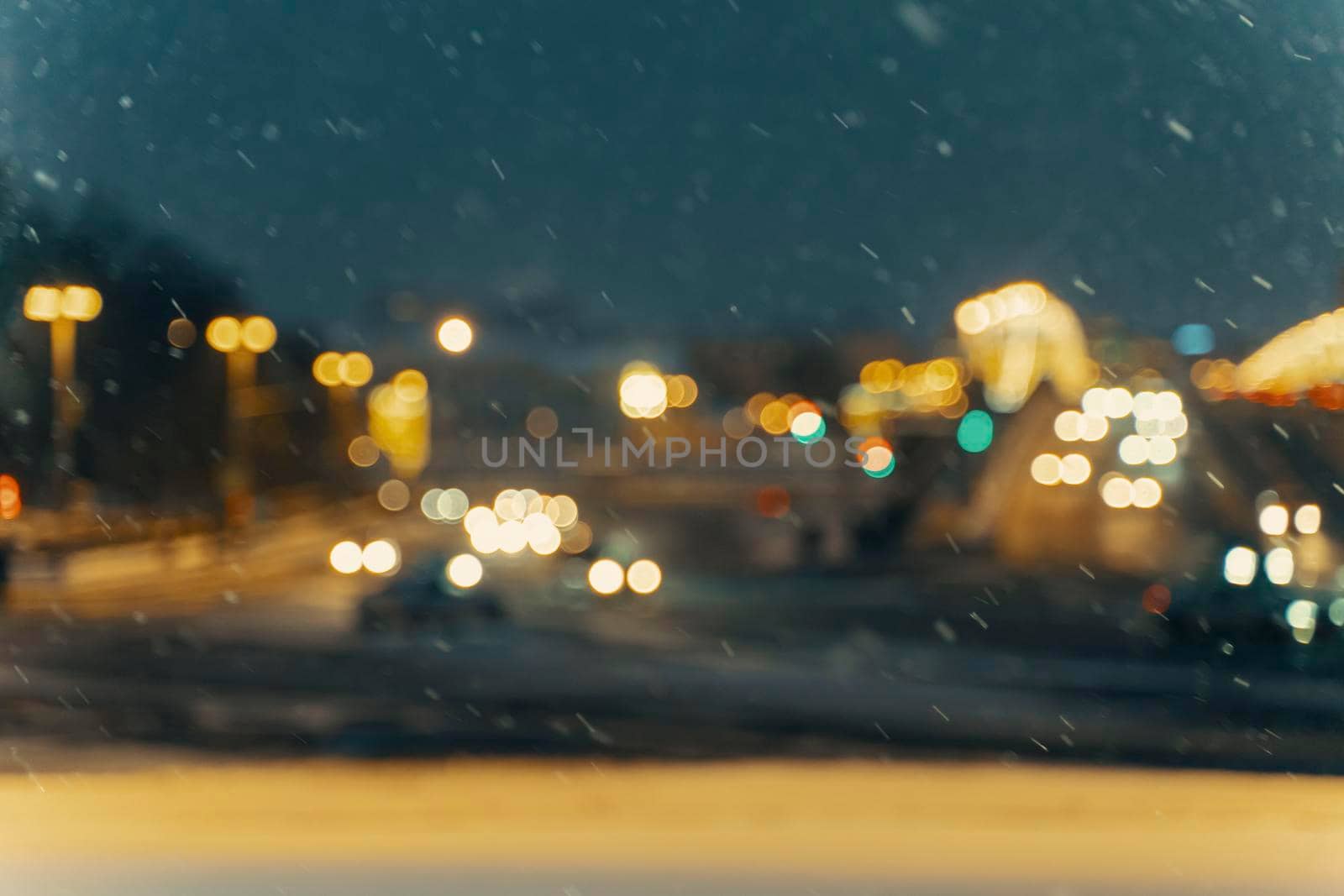 Winter blurred background with falling snow on the background of a city street.