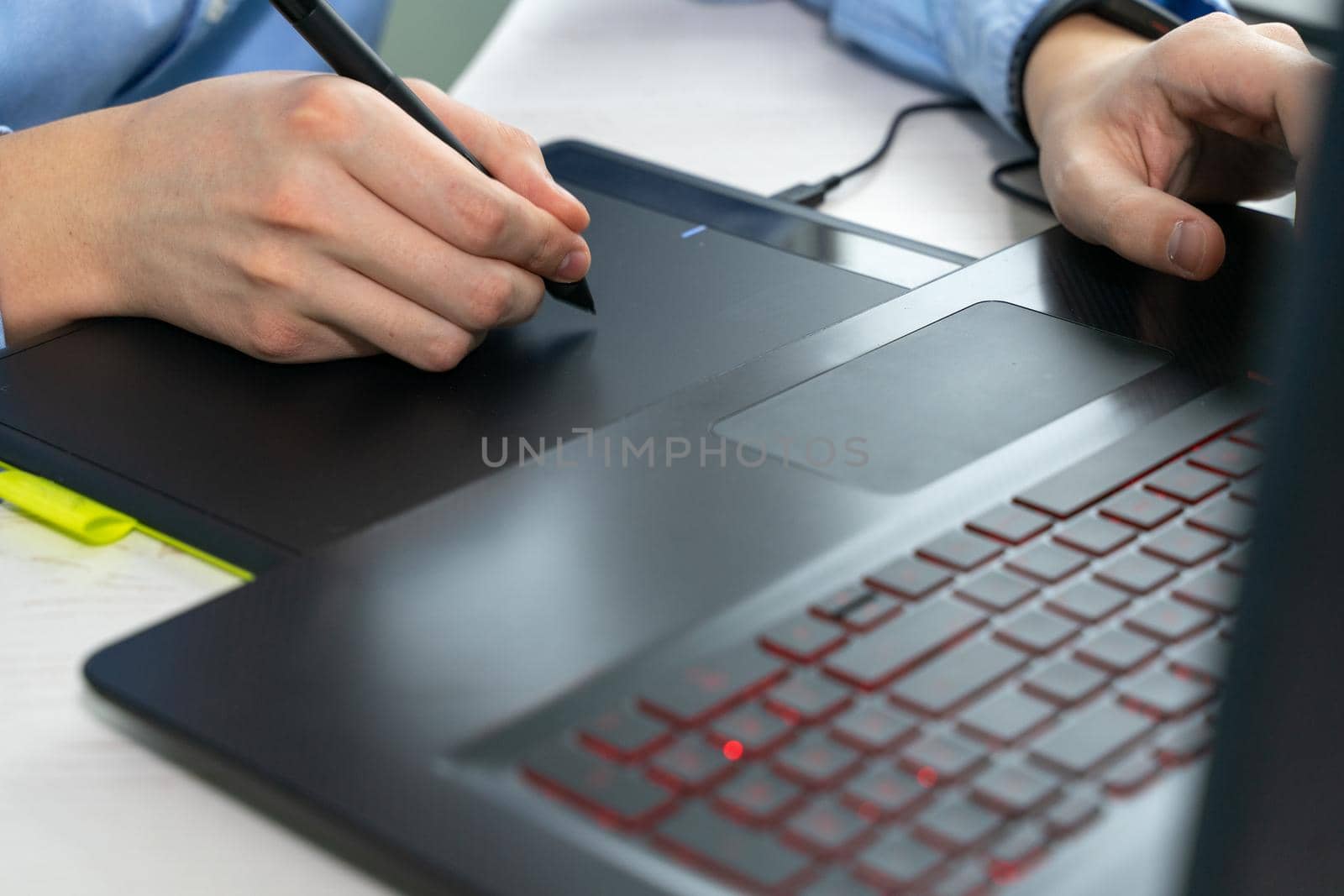 Graphic designer using digital tablet and computer in office. hands close up