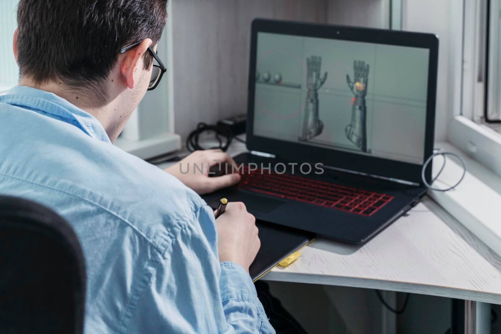 digital artist working on 3d graphics using a graphics tablet.