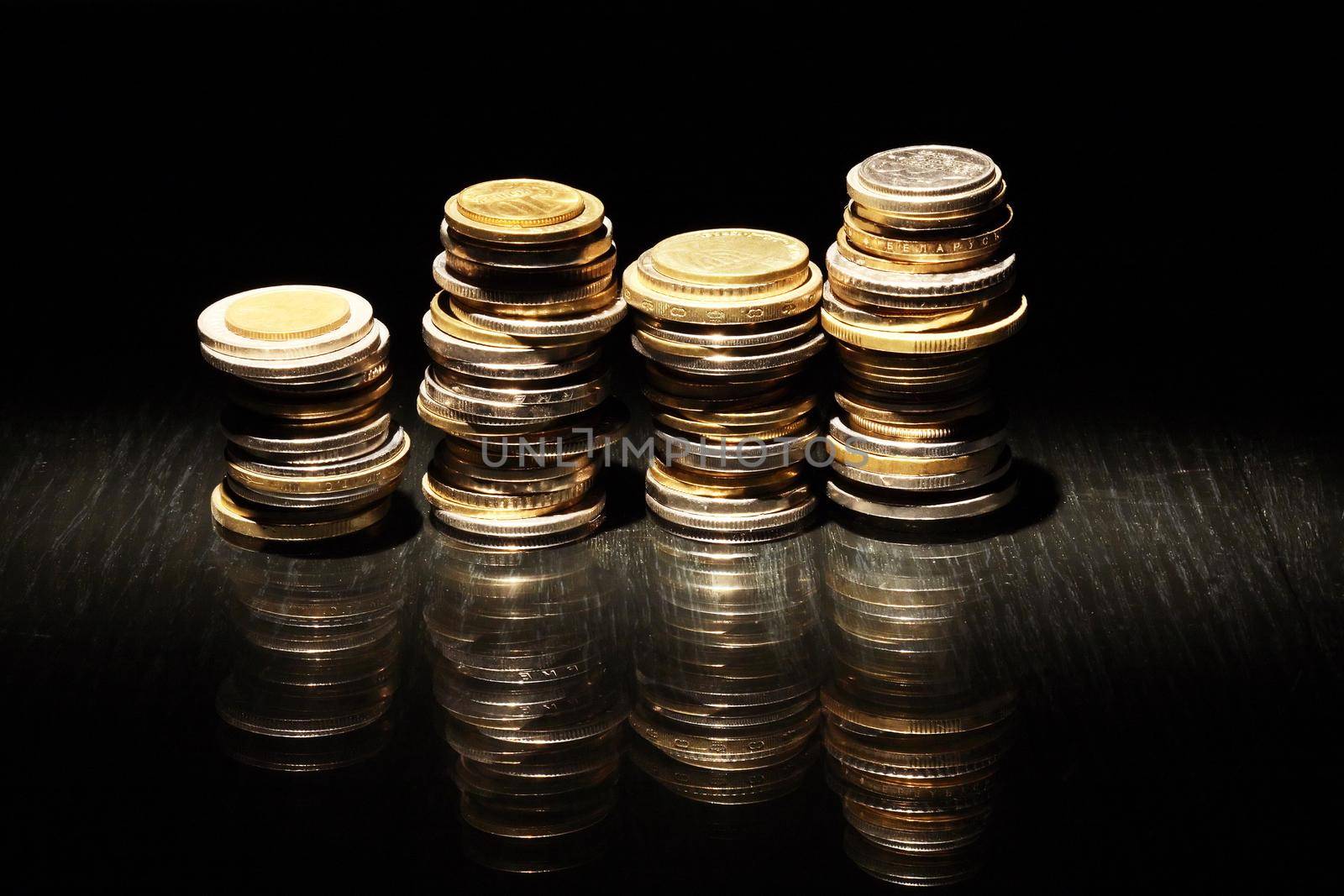 Set of various coins in a row on dark background