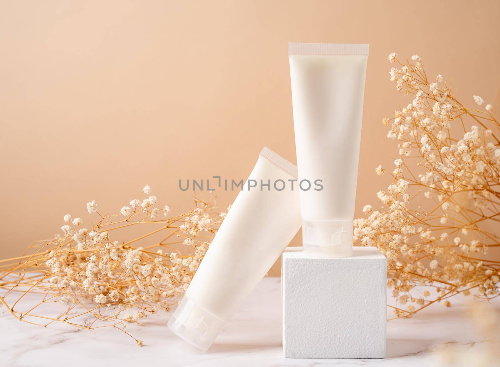 Cream tube mockup for branding presentation. Natural skincare beauty product on square white podium. Natural earthy colors, beige background