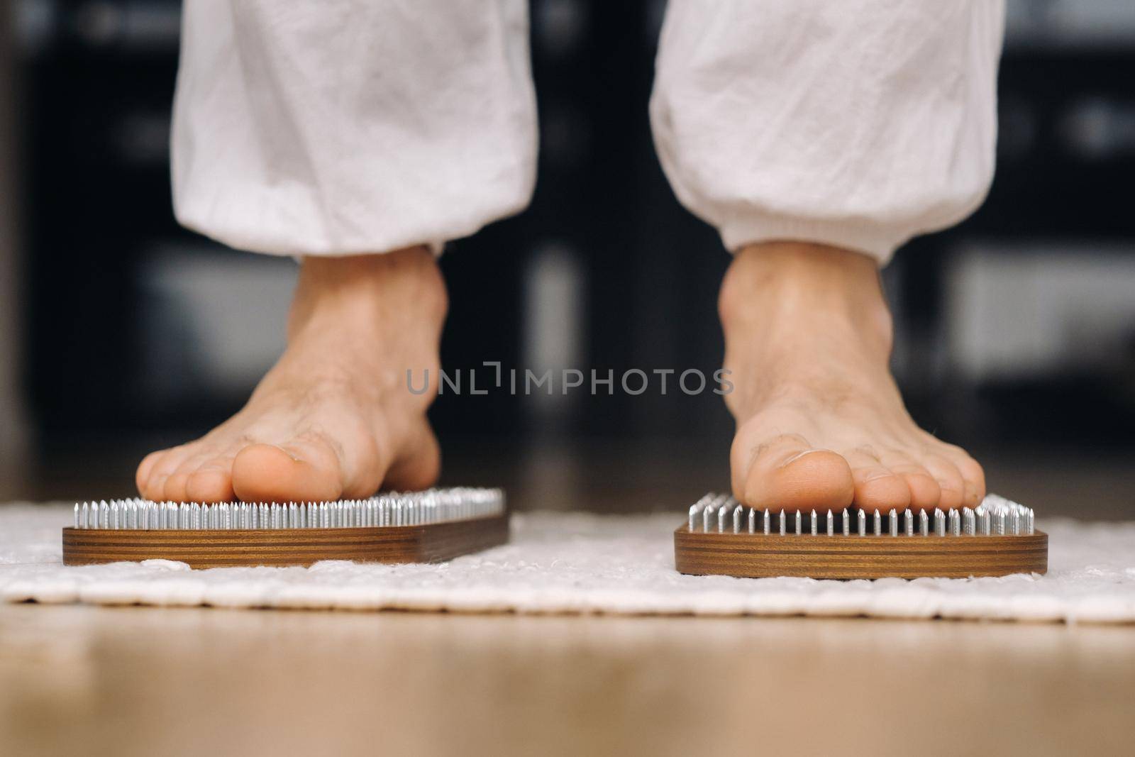 The man's feet are next to boards with nails. Yoga classes.