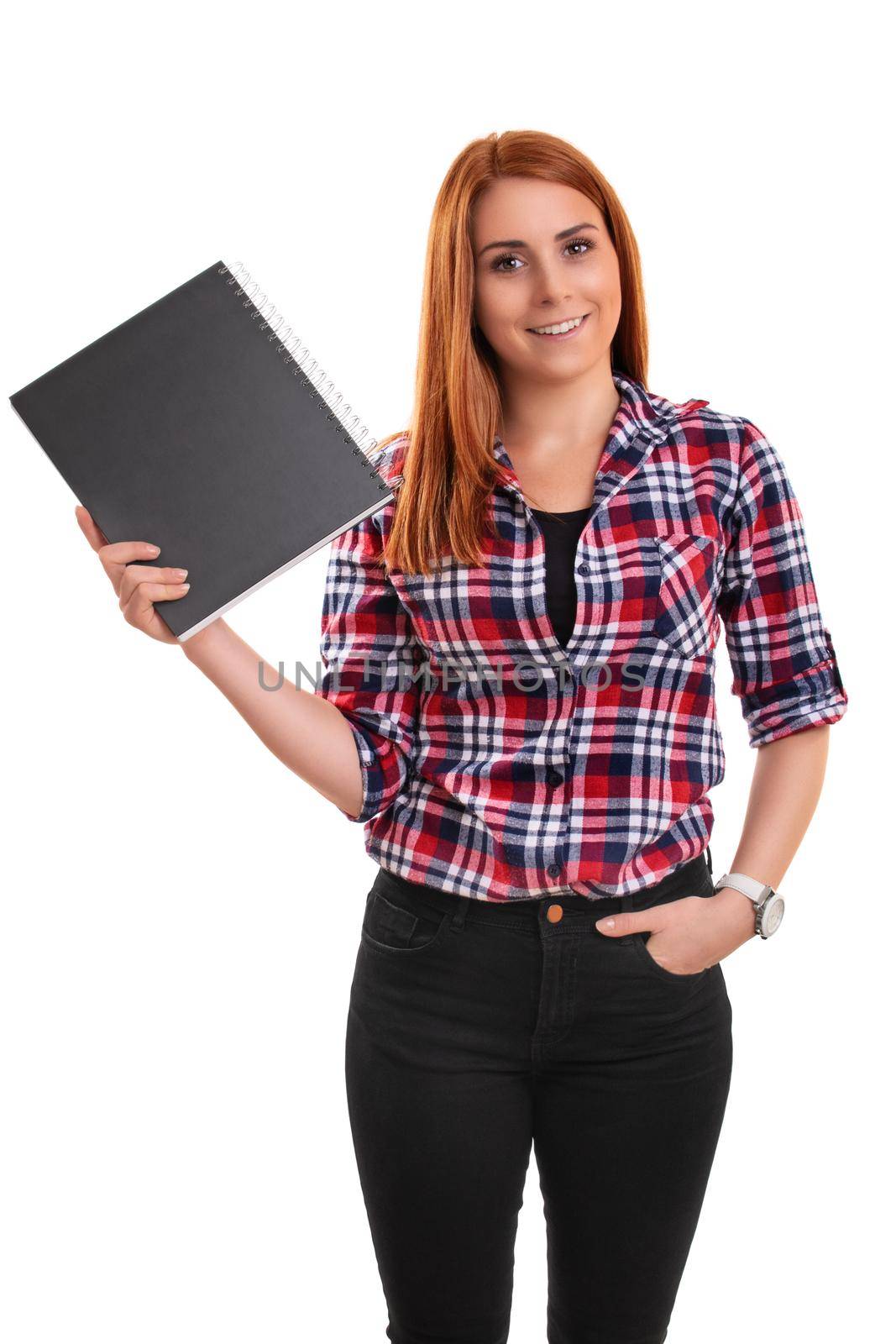 Smiling young redhead woman in plaid shirt holding a notebook in the hand, isolated on white background. Education, study, exams, achievement concept.