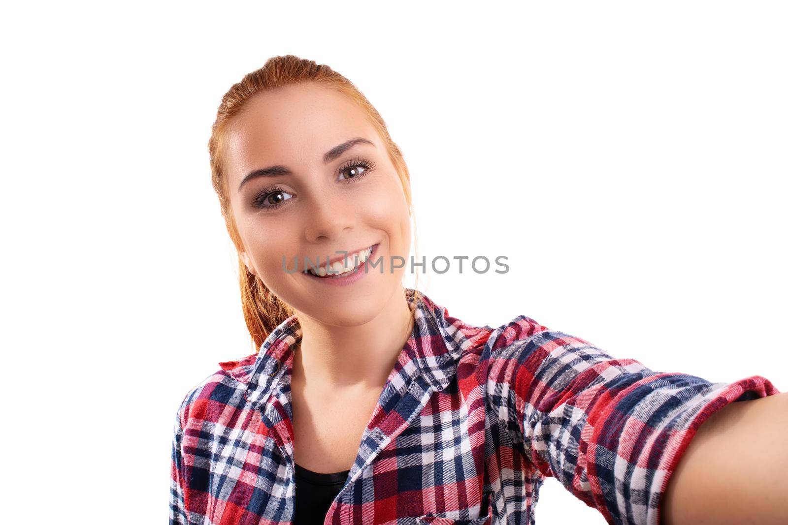 Close up of a beautiful young smiling girl taking a selfie, isolated on a white background. Social media and selfie concept.