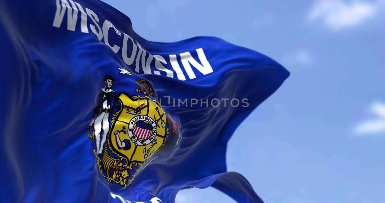 The US state flag of Wisconsin waving in the wind. by rarrarorro