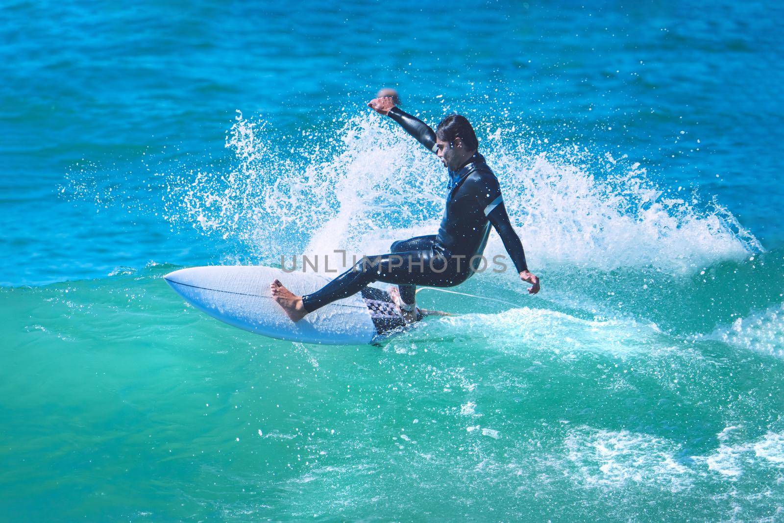 Surfer riding the wave on shortboard. Man catching waves in ocean. Water sports activity by DariaKulkova