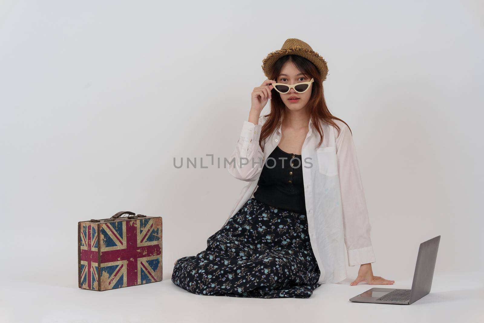 Charming woman choosing the summer trip by tourism plan by laptop computer. isolated over white background. by itchaznong