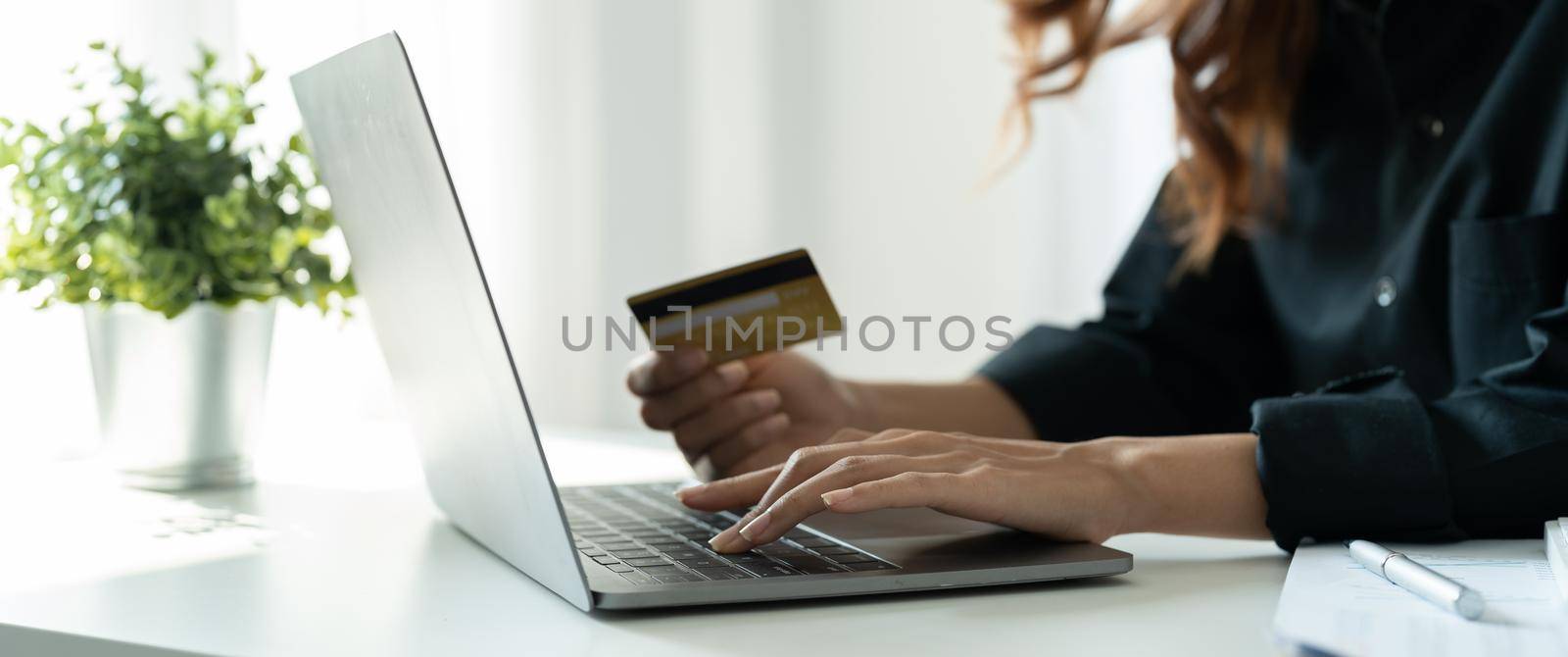 Young woman holding credit card and using smart phone for online shopping. Online payment shopping concept.
