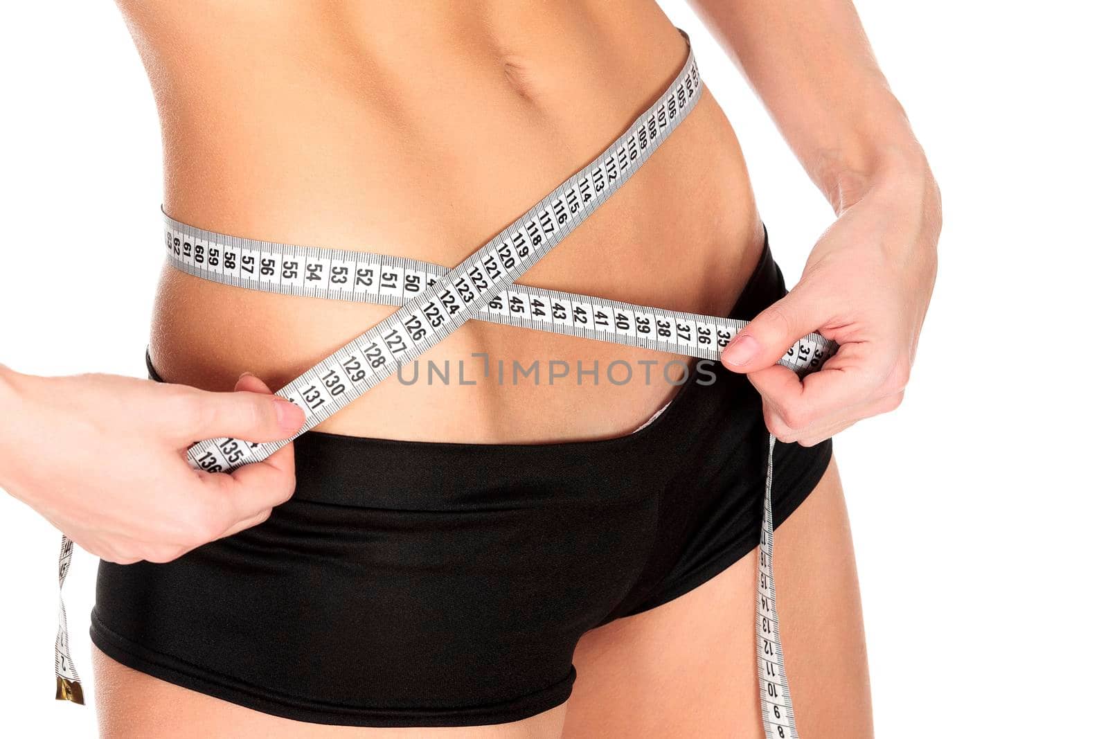 Slim woman measures her waistline, isolated on a white background