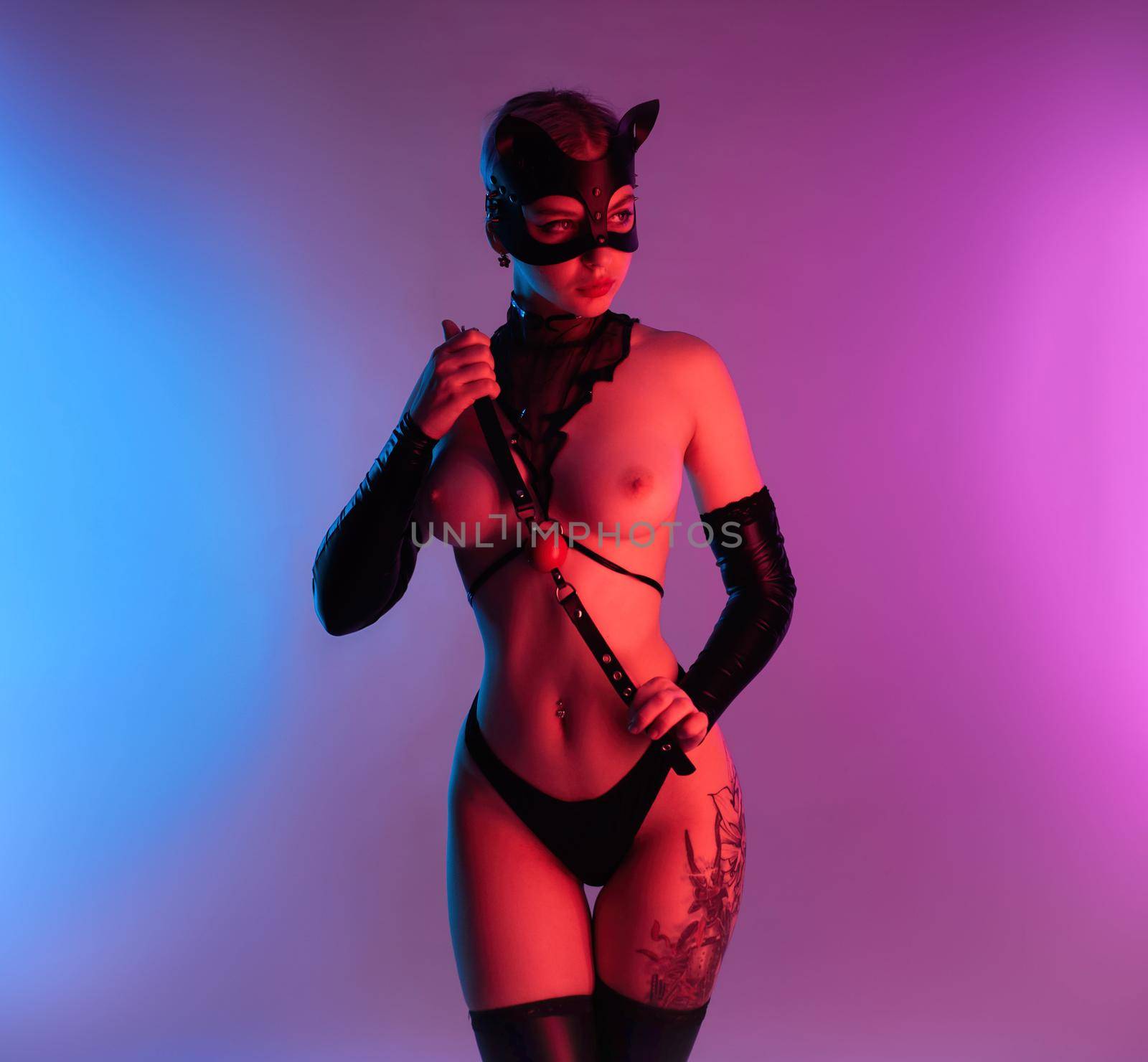 the sexy woman in a leather cat mask with a gag for bdsm sex toys