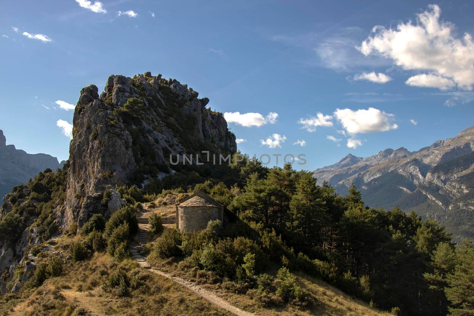 Hermitage under a rocky peak in the Pyrenees in a trekking route called Ermitas de Tella in Huesca province in Spain