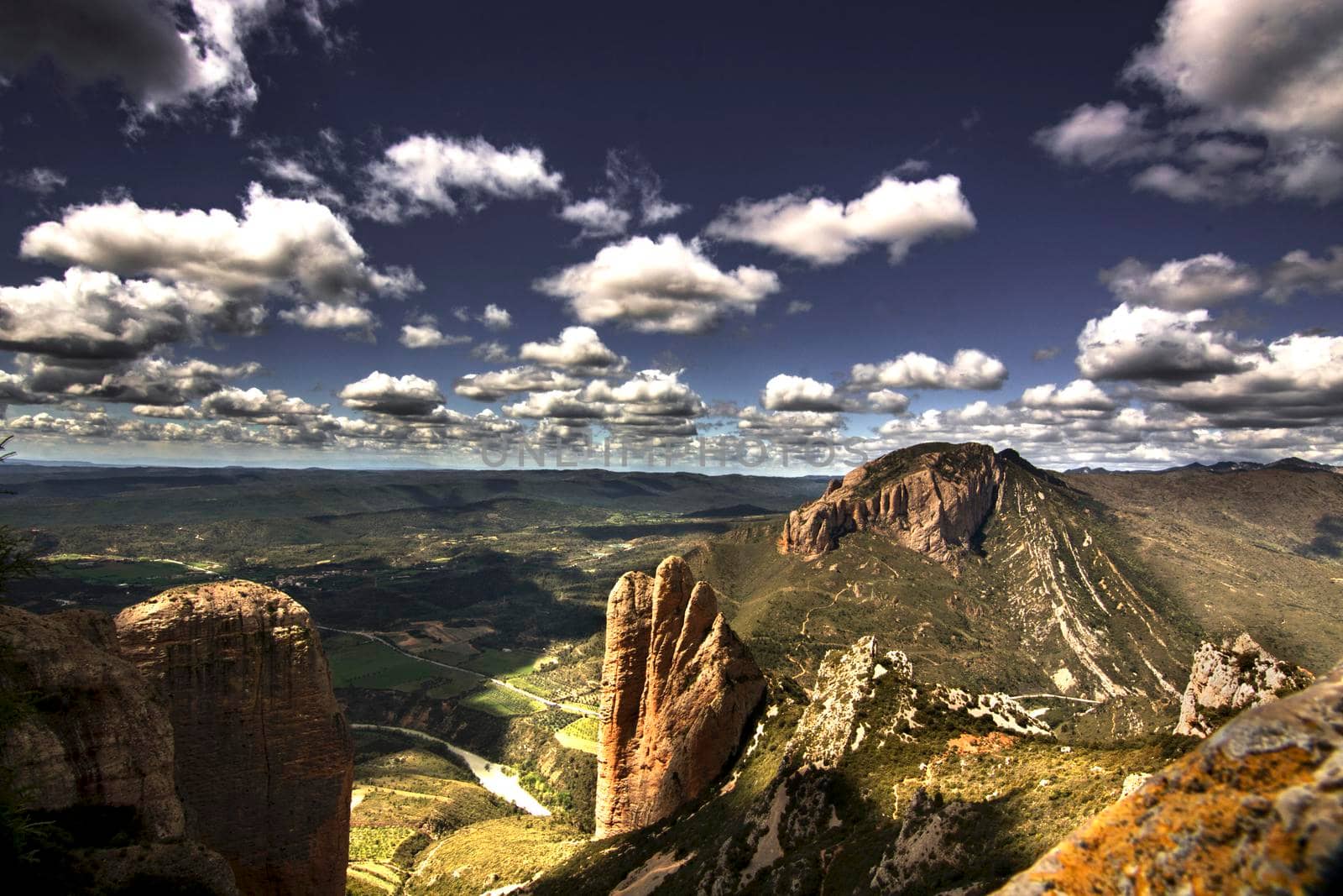 Vertical mountains called Mallos de Riglos under a cloudy sky in Huesca province in Spain