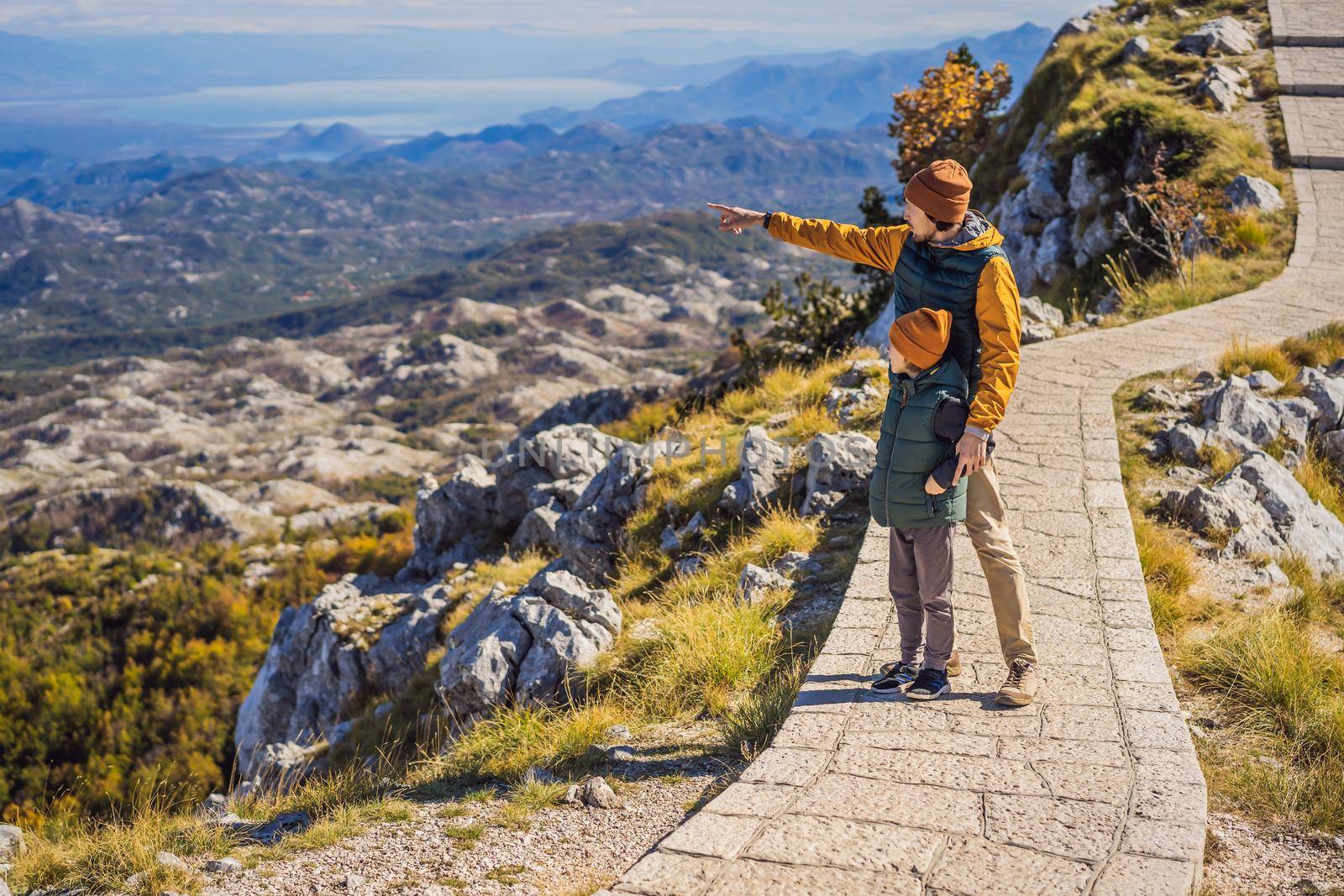 Dad and son travellers in mountain landscape at national park Lovcen, Montenegro. Travel to Montenegro with children concept.