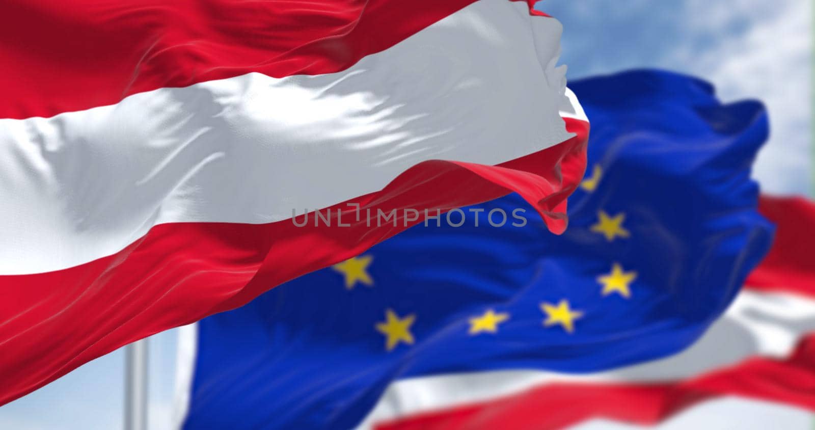 Detail of the national flag of Austria waving in the wind with blurred european union flag in the background on a clear day. by rarrarorro