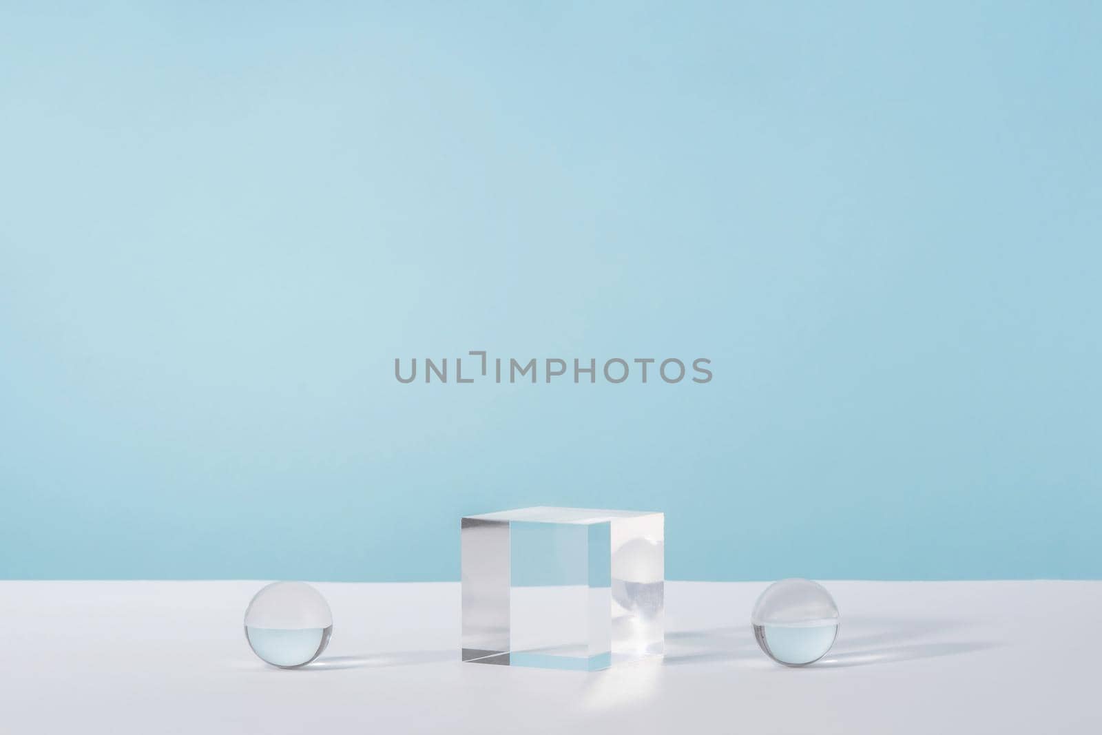 Pedestal cosmetic display glass podium platform with stylish props for product presentation, cosmetics geometric stand, mockup scene for jewellery mock up. Acrylic blocks and balls on blue background