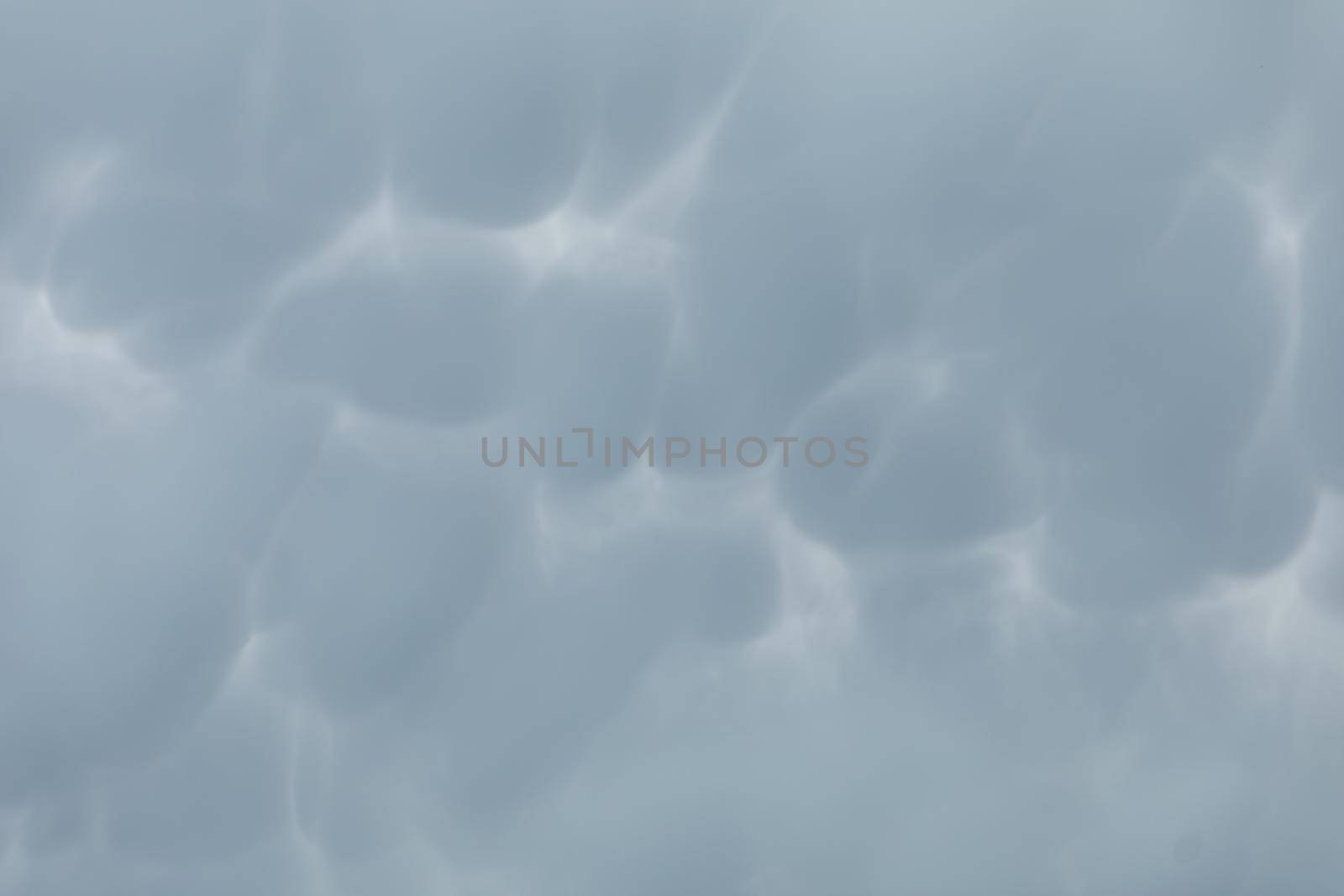 During unusually strong winds, clouds accumulate and gather into irregular bubbles. Close up frame of a slice of the sky.