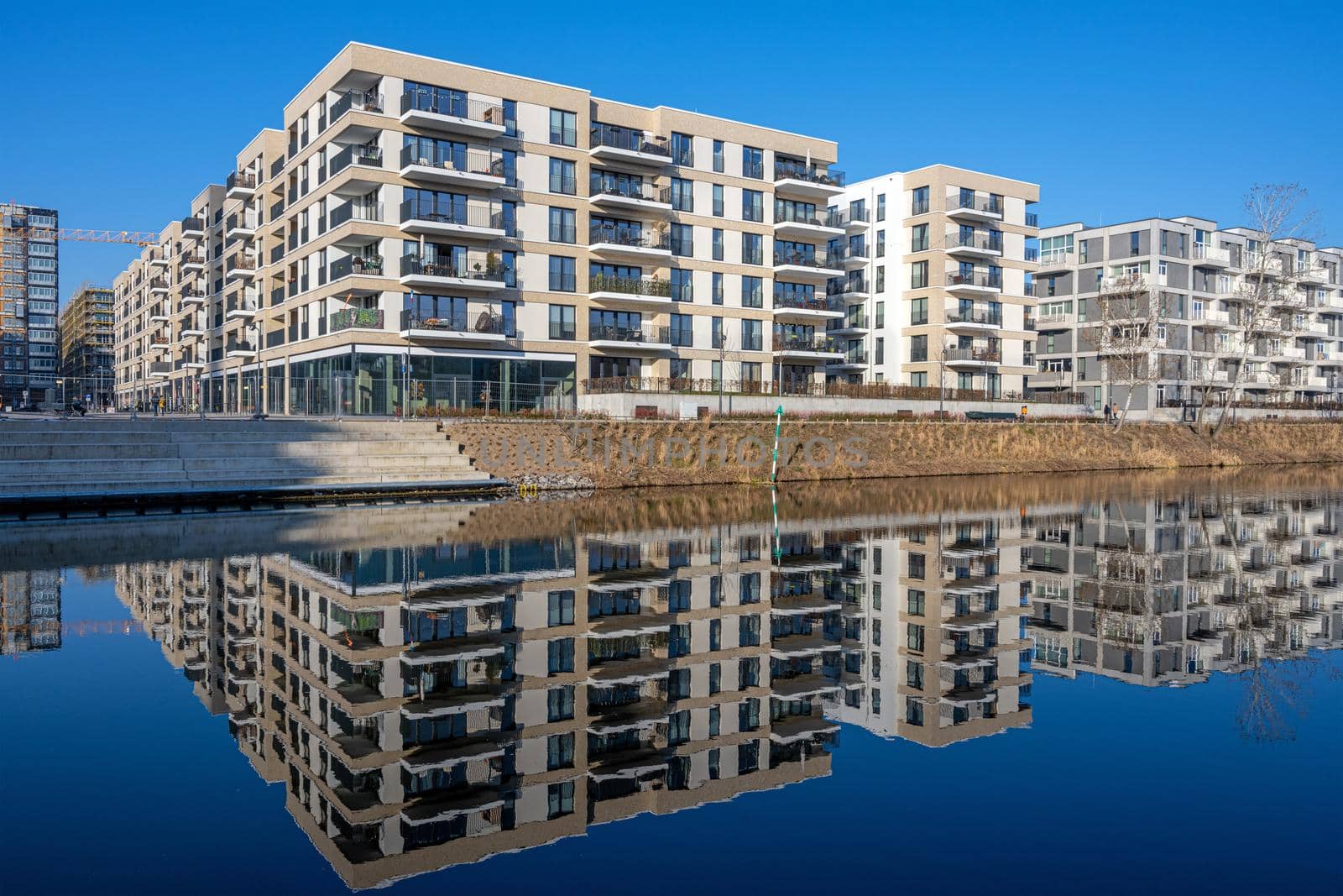 Modern apartment buildings in Berlin with a perfect reflection in a small canal