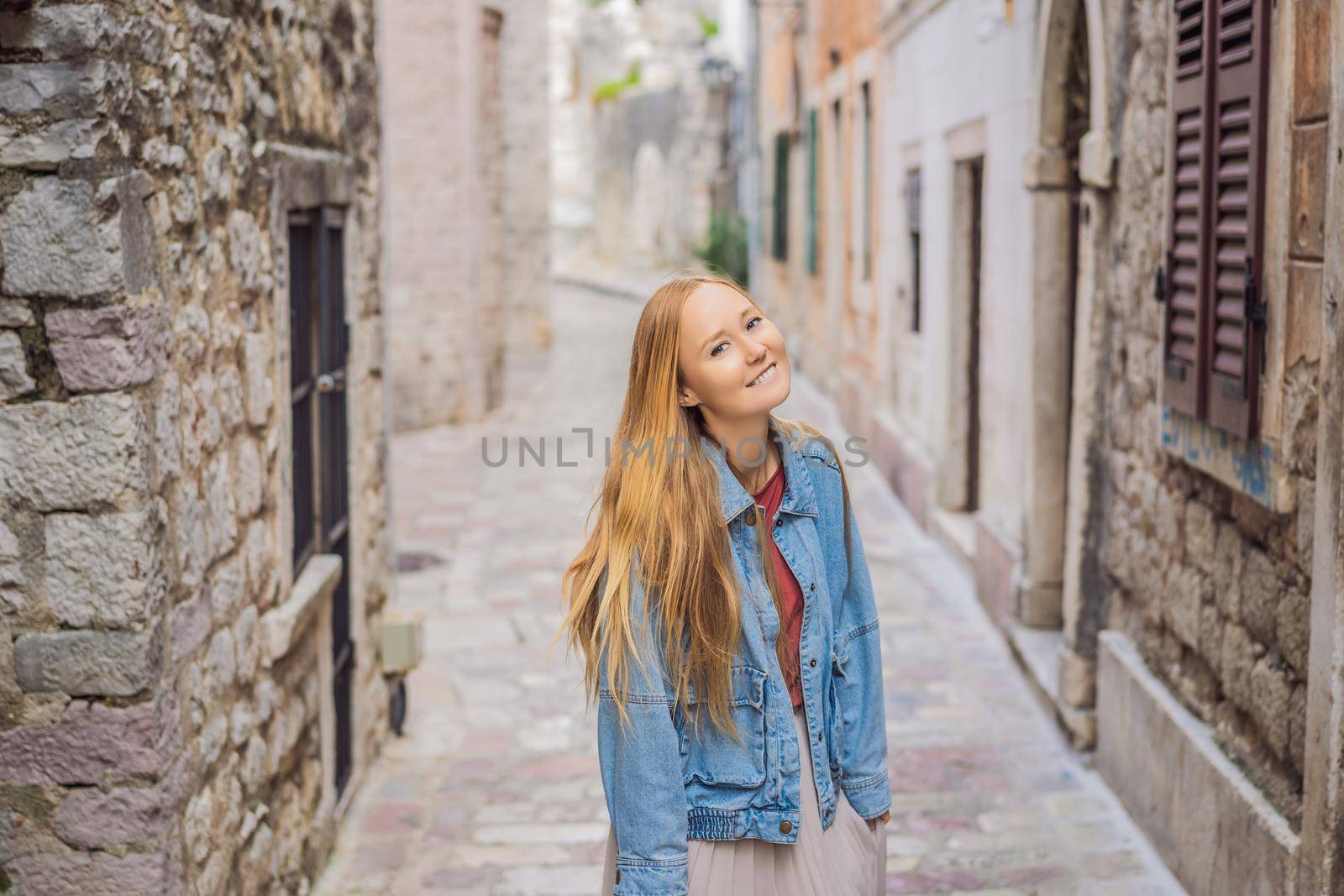 Woman tourist enjoying Colorful street in Old town of Kotor on a sunny day, Montenegro. Travel to Montenegro concept by galitskaya