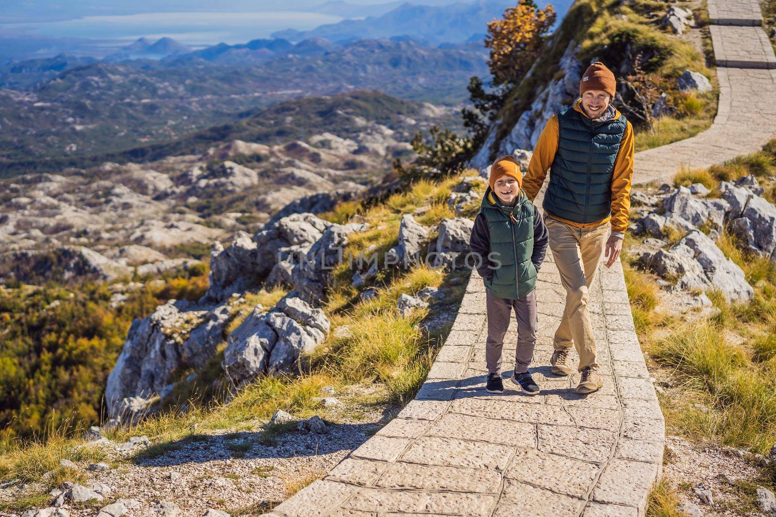 Dad and son travellers in mountain landscape at national park Lovcen, Montenegro. Travel to Montenegro with children concept.