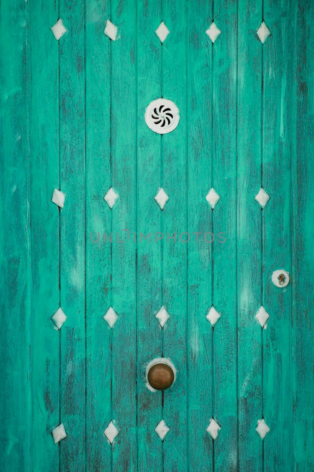Green wooden door with white metal details in Altea, Alicante, Spain.