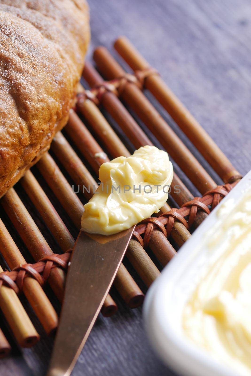 slice of a butter on a paper on table .