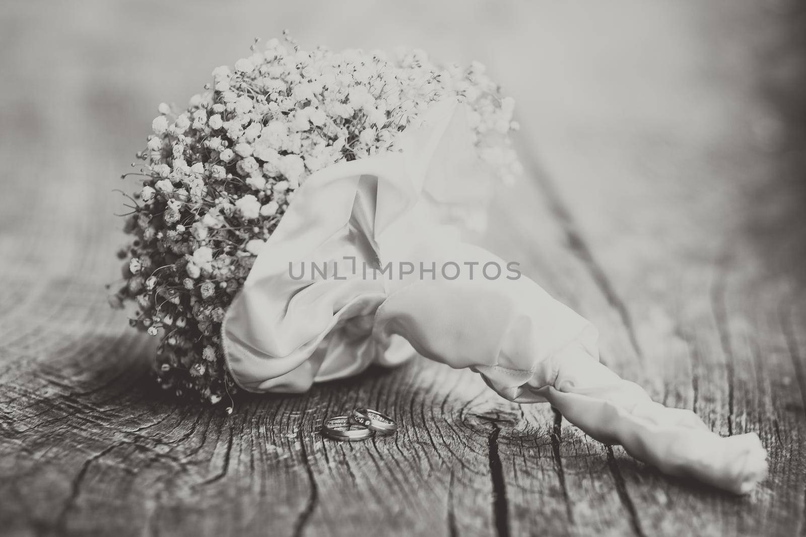 Wedding bouquet and rings on a dark wooden background.