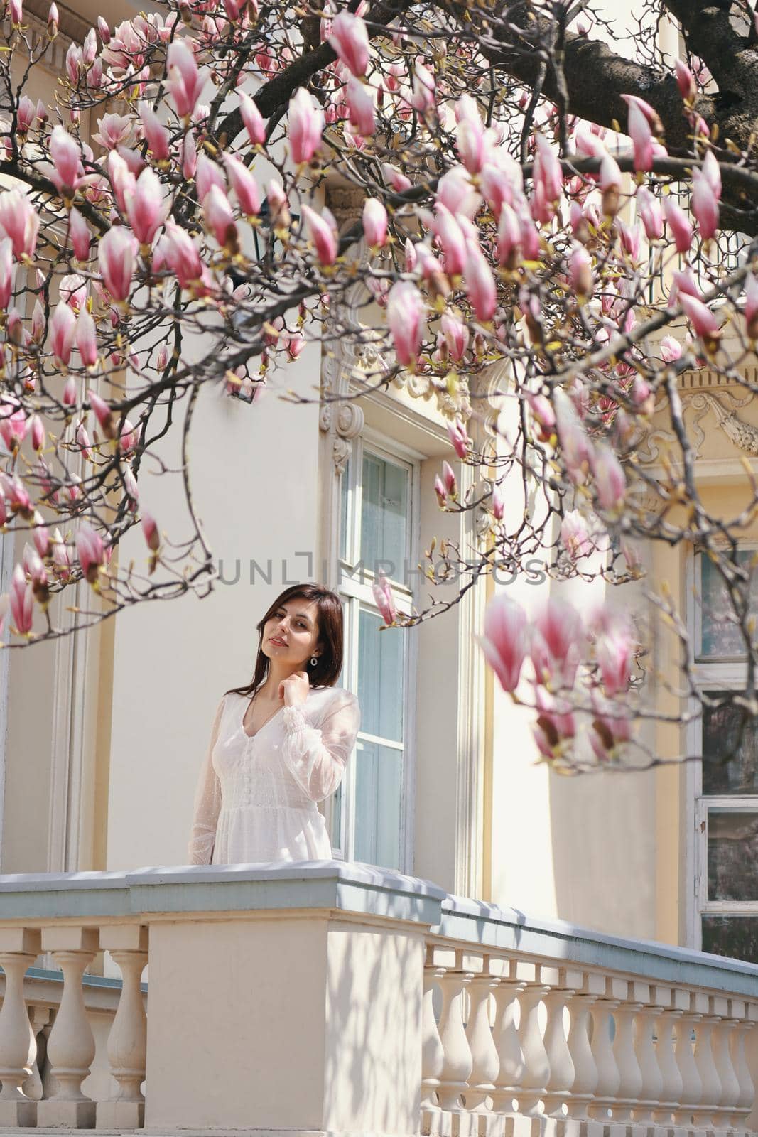 Beautiful brunette girl in Garden with blooming magnolia trees