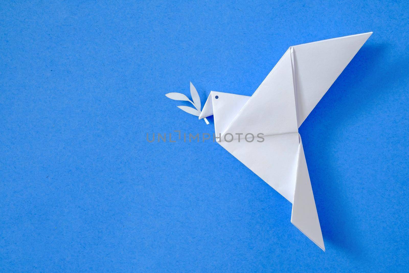 Dove of peace on blue sky background concept from origami toy leisure and hobby and poster with emblem no to war and yes to peace.