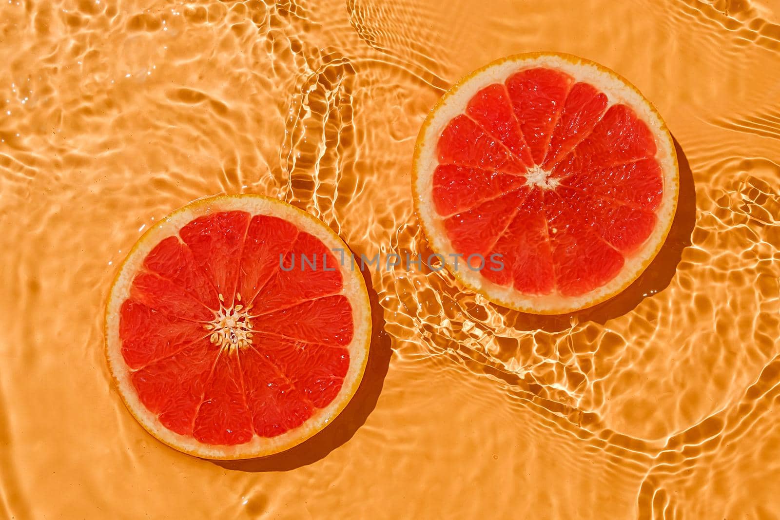 Texture summer citrus red raw fresh grapefruit with fresh water and waves. by sergii_gnatiuk