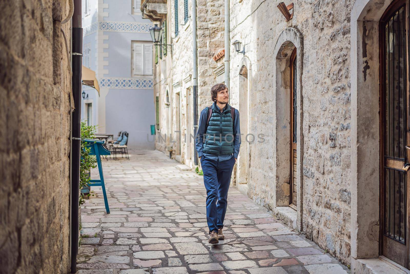 Man tourist enjoying Colorful street in Old town of Kotor on a sunny day, Montenegro. Travel to Montenegro concept.