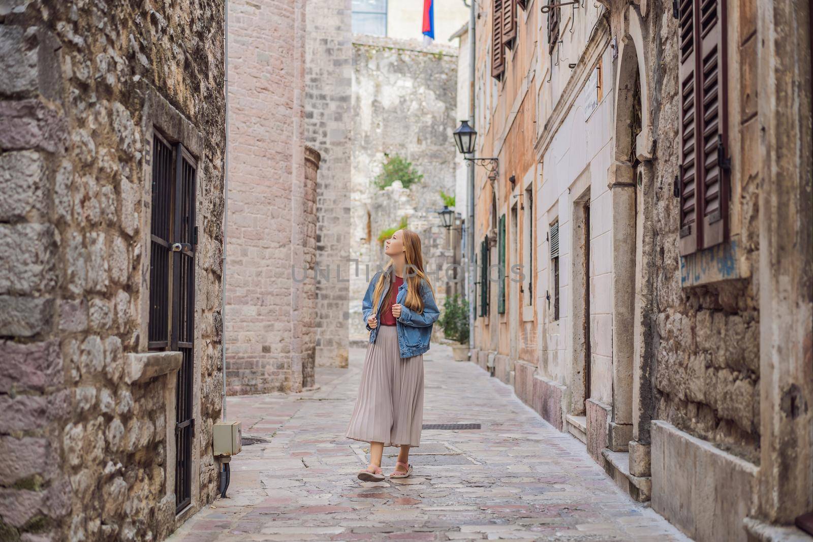 Woman tourist enjoying Colorful street in Old town of Kotor on a sunny day, Montenegro. Travel to Montenegro concept.