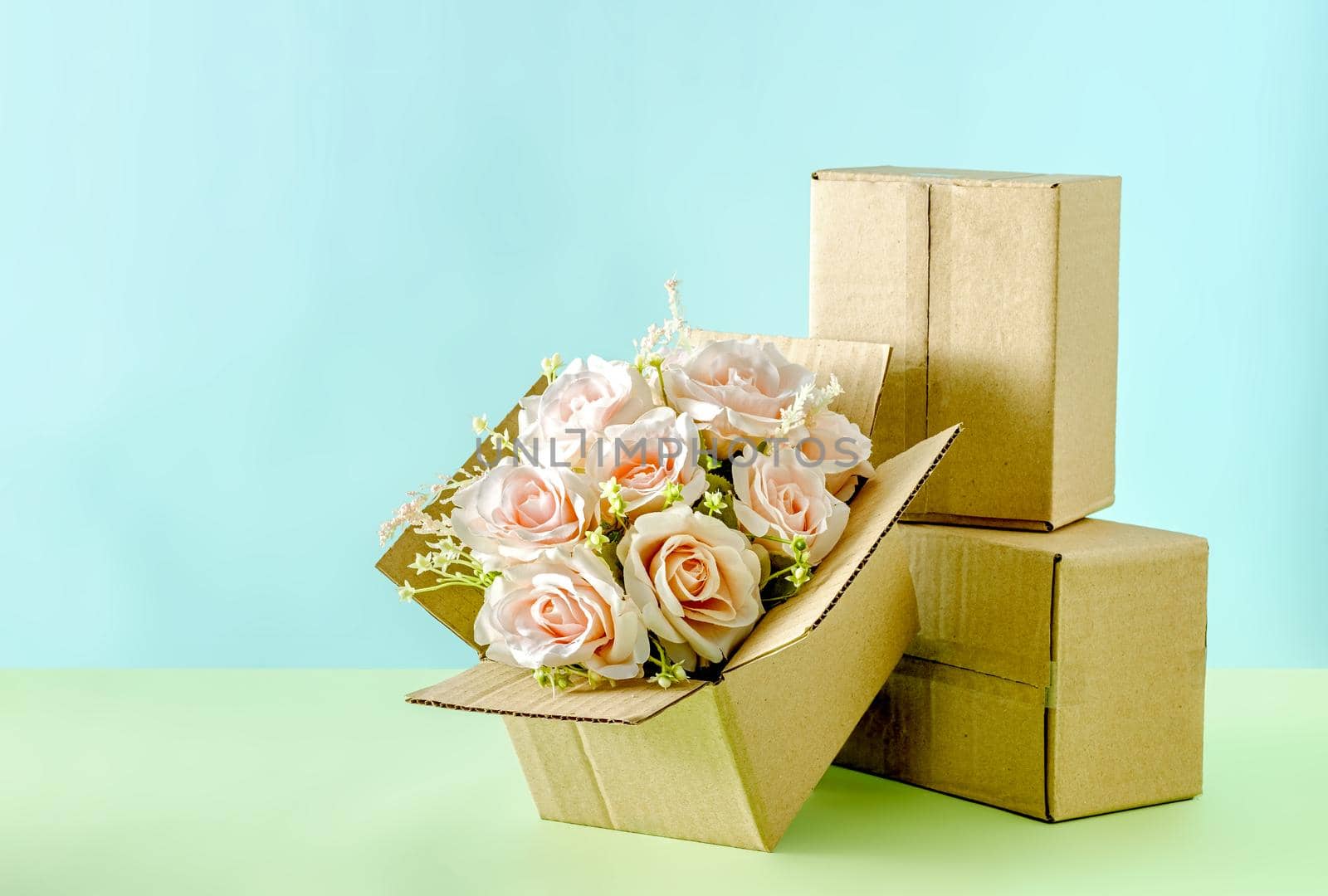 A blooming bouquet of pink roses in a cardboard box of a delivery service for congratulations on Valentine's Day or a wedding or other holiday.