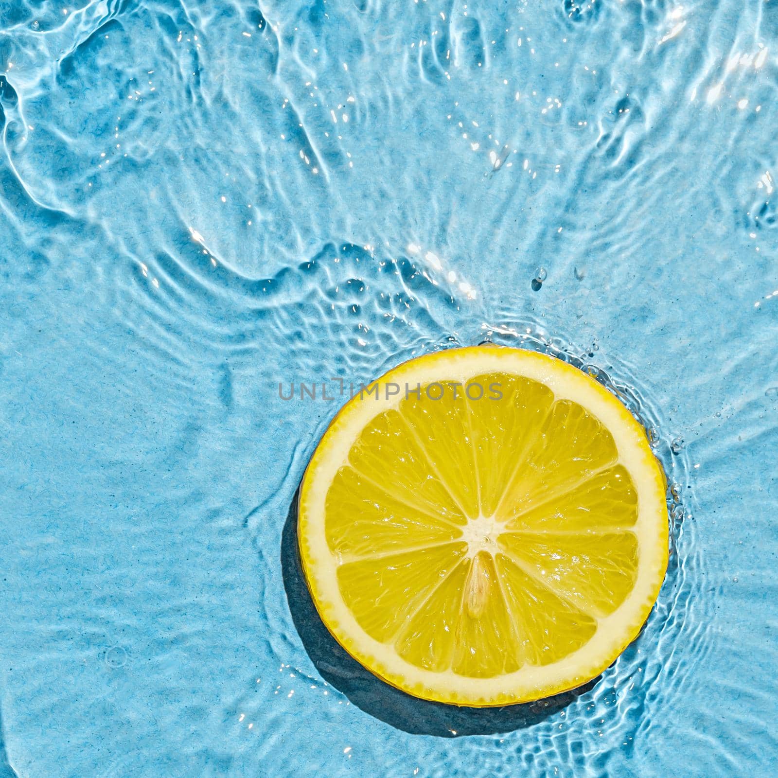 Tropics orange summer vegetarian bright juicy lemon in transparent summer blue water with wave motion.